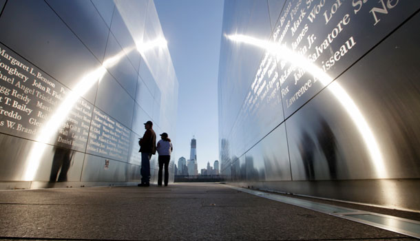 The construction of One World Trade Center, now up to 104 floors, is seen Tuesday, Sept. 11, 2012, across the Hudson River, as people stop to read names in New Jersey's memorial to the 749 people from the state lost during the Sept. 11 terrorist attacks on the World Trade Center. /AP Photo/Mel Evans