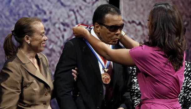 Retired boxing champion Muhammad Ali receives the Liberty Medal from his daughter Laila Ali with his wife Lonnie Ali at his side during a ceremony at the National Constitution Center, Thursday, Sept. 13, 2012, in Philadelphia. /AP Photo/Matt Rourke