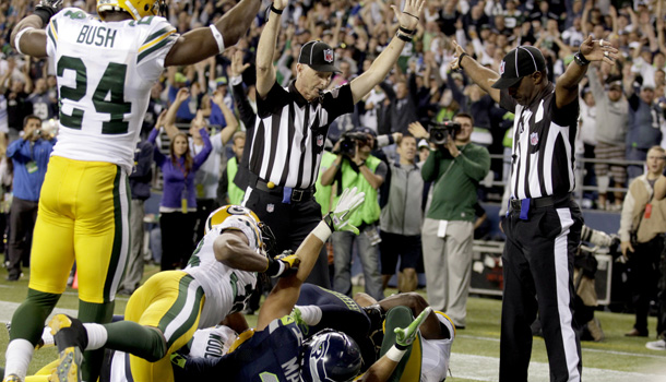 In a Sept. 24 photo, an official, c, signals a touchdown by Seattle Seahawks wide receiver Golden Tate as another official, at right, signals a touchback on the controversial last play of an NFL football game against the Green Bay Packers that brought the issue of replacement refs to a tipping point. The NFL and the referees' union reached a tentative contract agreement ending an impasse that began in June when the league locked out the officials and used replacements instead. /AP Photo/Stephen Brashear, File