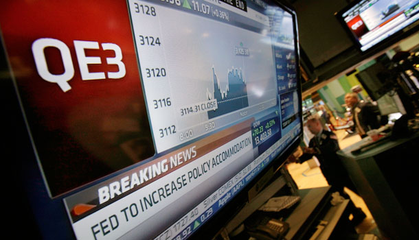 The rate decision of the Federal Reserve is announced on a television screen on the floor of the New York Stock Exchange Thursday, Sept. 13, 2012. The Federal Reserve unleashed a series of aggressive actions Thursday intended to stimulate the still-weak economy by making it cheaper for consumers and businesses to borrow and spend. /AP Photo/Richard Drew