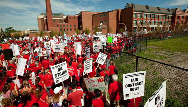 A large group of public school teachers marches past John Marshall Metropolitan High School on Wednesday, Sept. 12, 2012 in West Chicago. Teachers walked off the job Monday for the first time in 25 years over issues that include pay raises, classroom conditions, job security and teacher evaluations. /AP Photo/Sitthixay Ditthavong